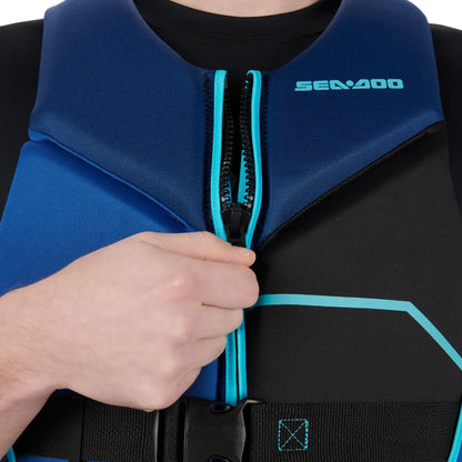 Person wearing a blue and black life jacket with a visible brand logo, holding the zipper.
